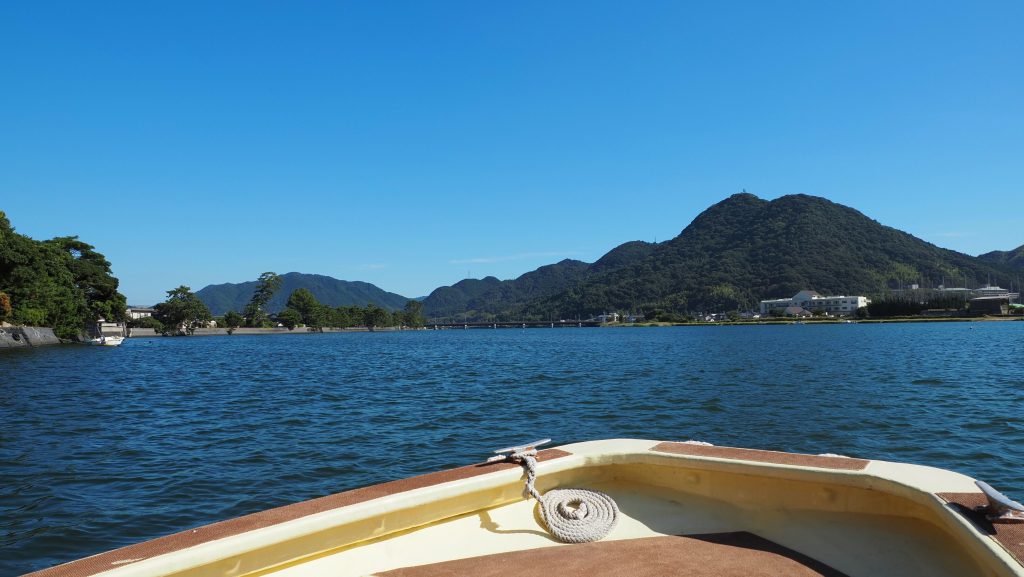 船上から眺める萩の水辺と山並みの風景