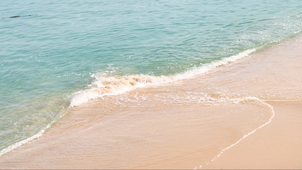 姉子の浜の白い砂浜に打ち寄せるエメラルドグリーンの波